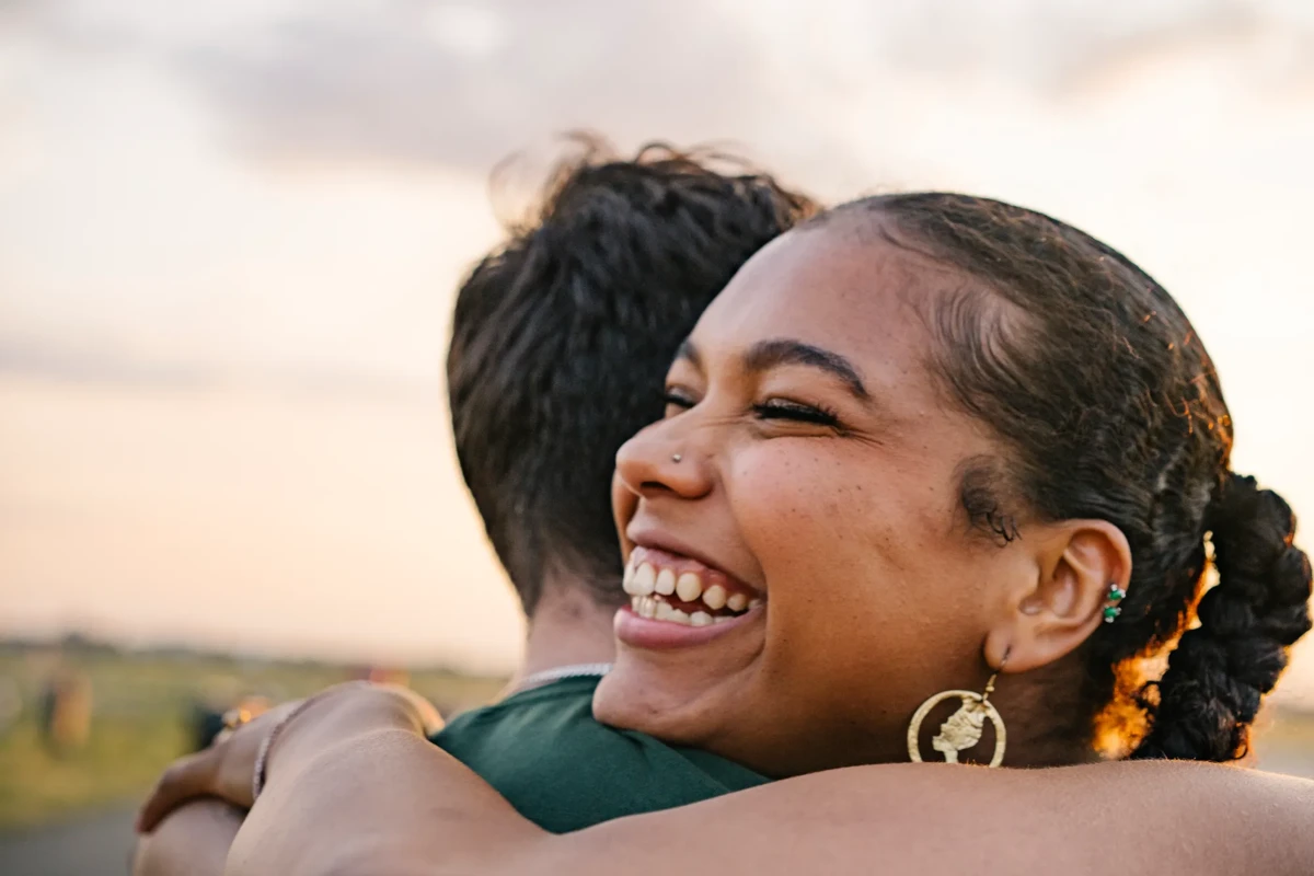 Portrait of the face of a female person generation z hugging a male person and laughing